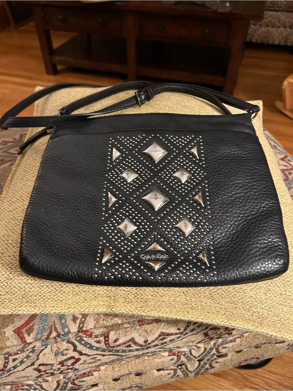 Leather shoulder bag with metal embellishment on front by Calvin Klein